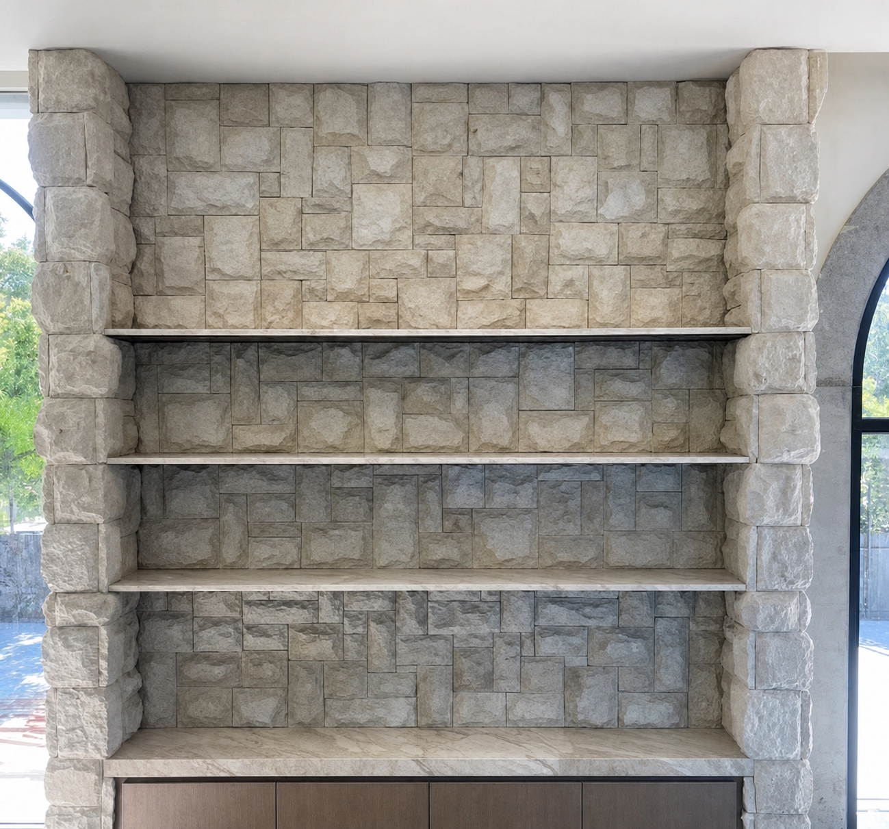 Floor-to-ceiling sandstone-clad shelving framed by solid stone corners